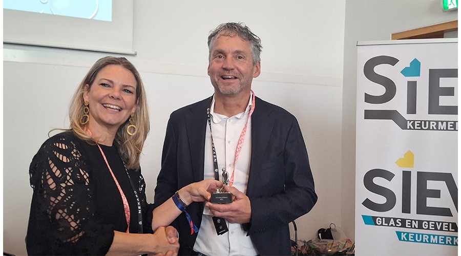 Mede-bestuurslid Rolien van Groeningen toont haar respect voor het 12,5 jarig lidmaatschap van Schilten Schoonmaak, het bedrijf van haar collega-bestuurslid Antoine Verhoef.