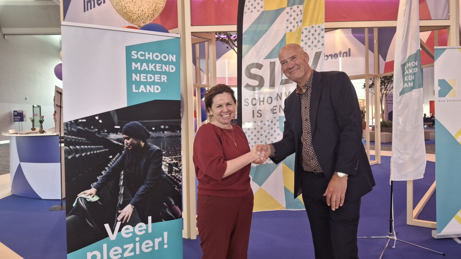 Ilse van Hijfte (SChoonmakend Nederland) en Paul Fok (SIEV) schudden elkaar de hand op een goede samenwerking tussen beide brancheorganisaties  in de toekomst.