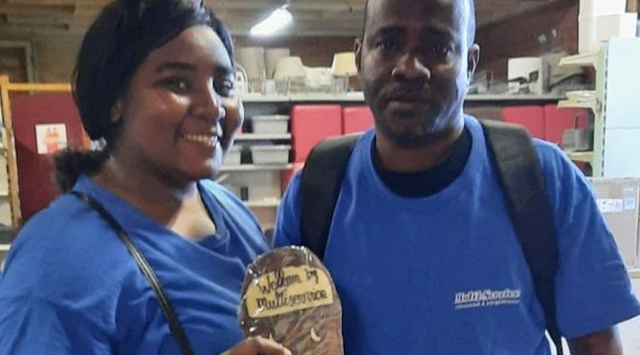 Bewoners van het AZC tonen een bordje waarop zij welkom worden door Multi Service Schoonmaak.