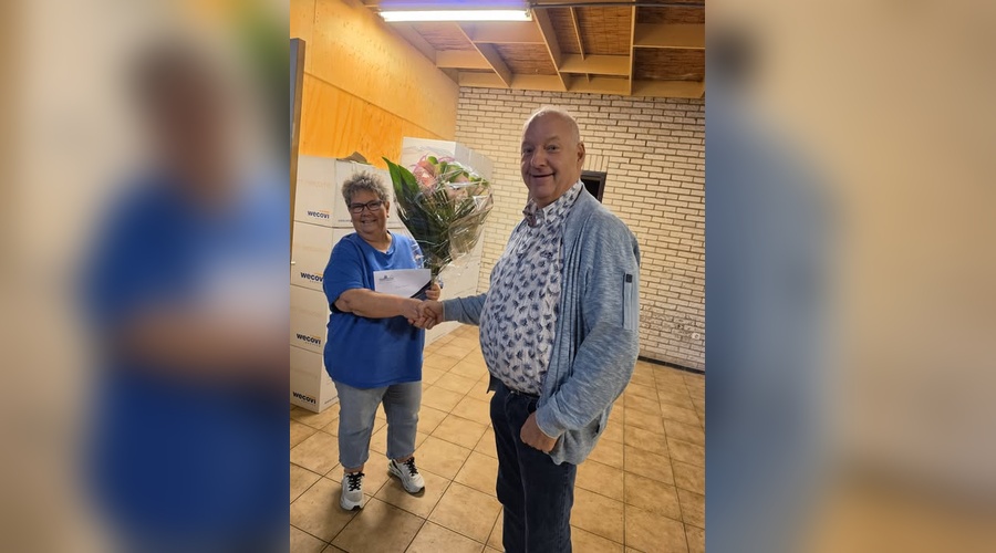 Leanne Berkers ontvangt voor haar jubileum een fraaie bos bloemen van Frank Verberne.
